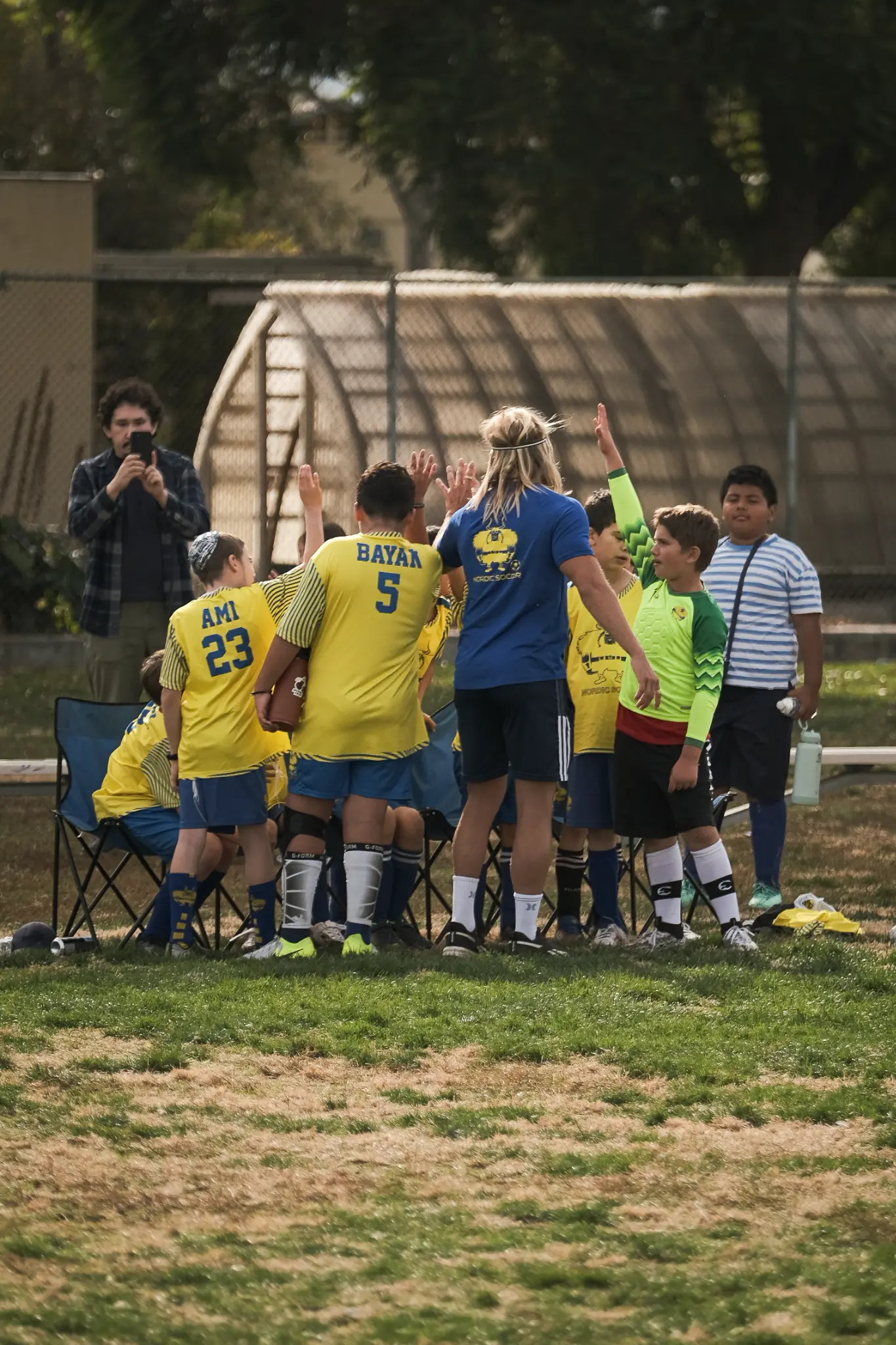 Nordic Soccer coach demonstrating proper shooting technique to young players during training at Sherman Oaks Elementary Charter